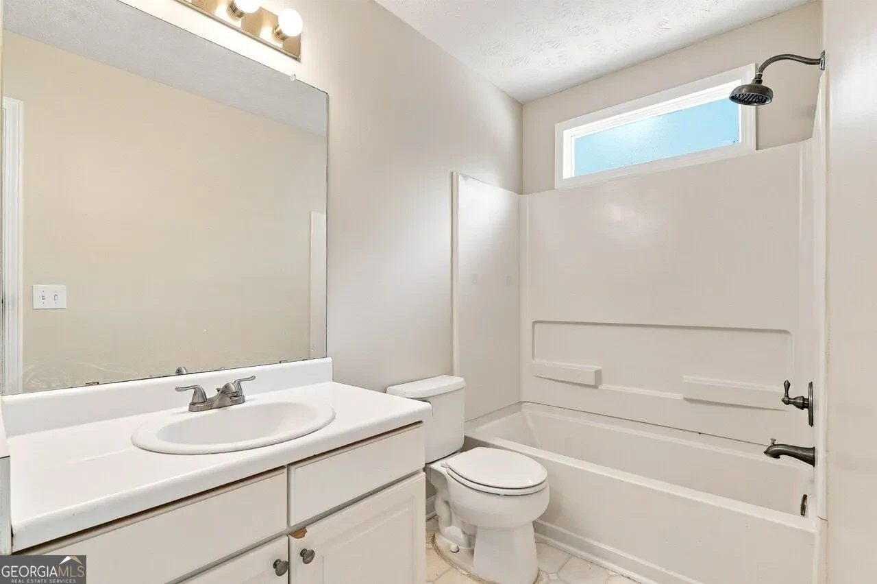 Powder room with pedestal sink and floral wallpaper